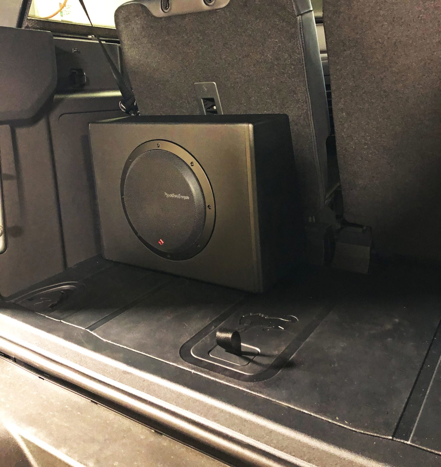 A Rockford Fosgate powered subwoofer enclosure standing upright behind the rear seat of the Ford Bronco