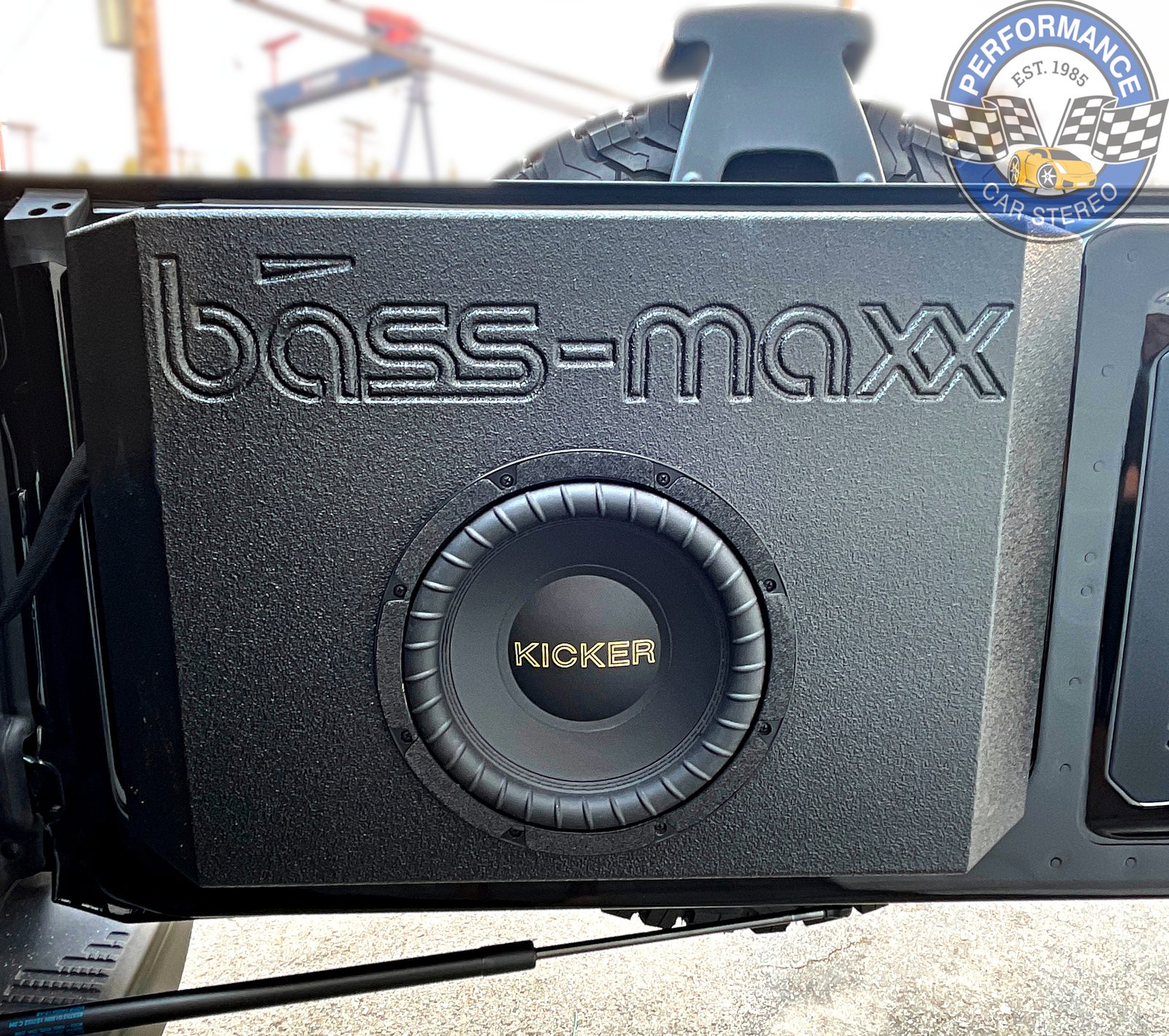 A Bass-Maxx enclosure holding a Kicker subwoofer, mounted to the inside of the Bronco's open tailgate