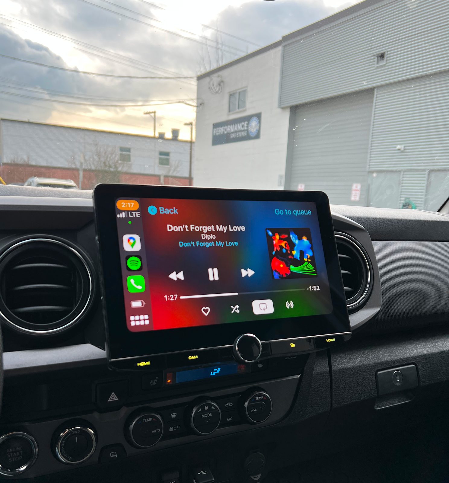 The Kenwood 10.1-inch floating screen fitted in the Tacoma's dash, showing Apple CarPlay playing music